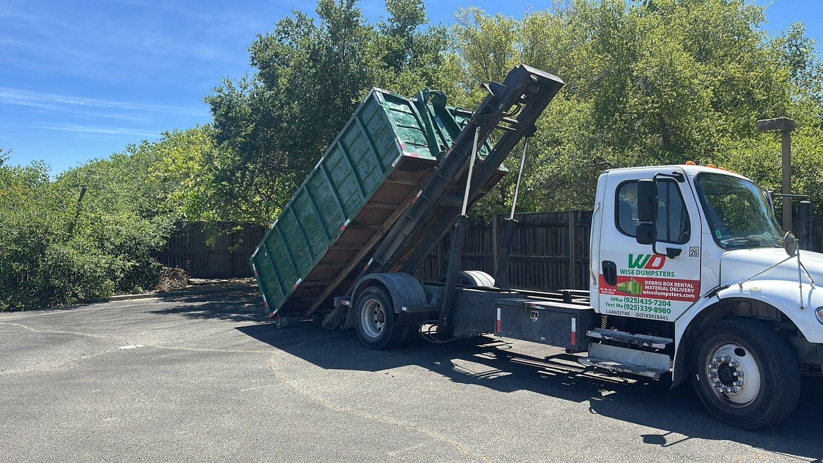 Wise Dumpsters roll-off truck mid-action