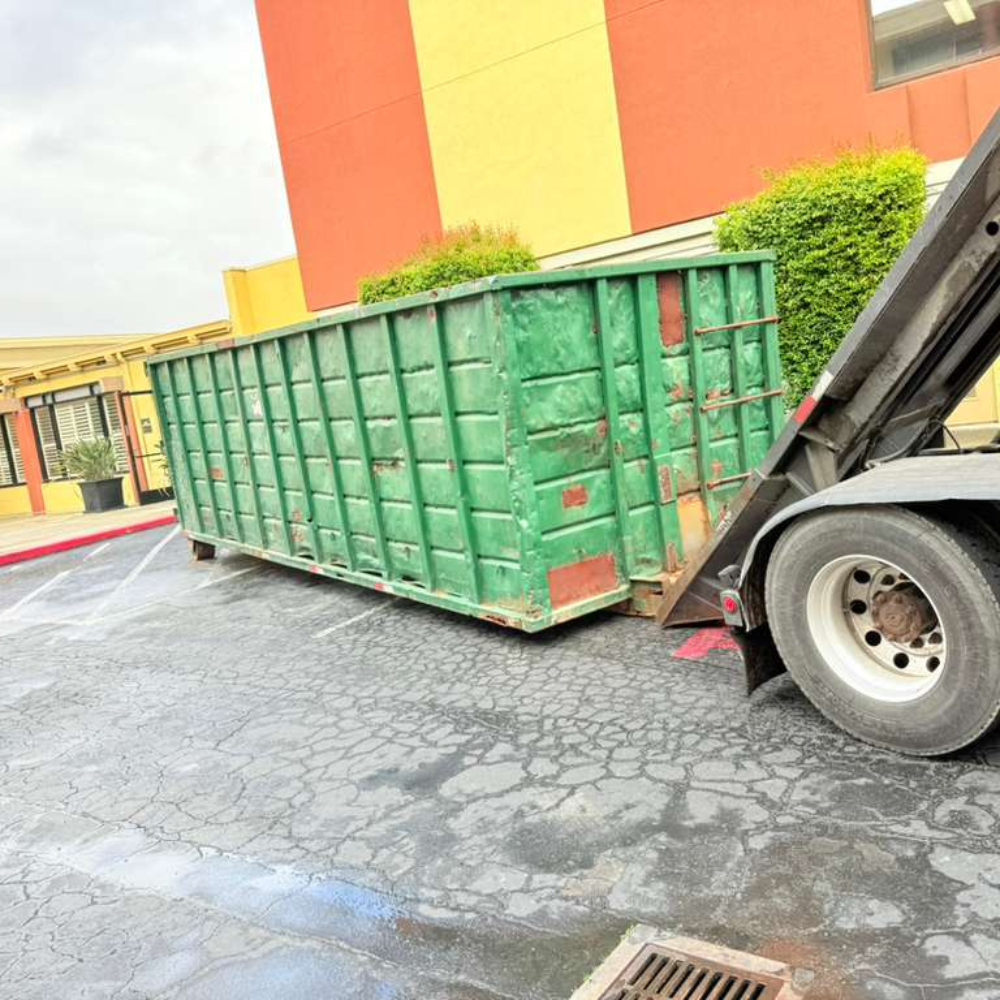 Green dumpster on a sunny commercial lot