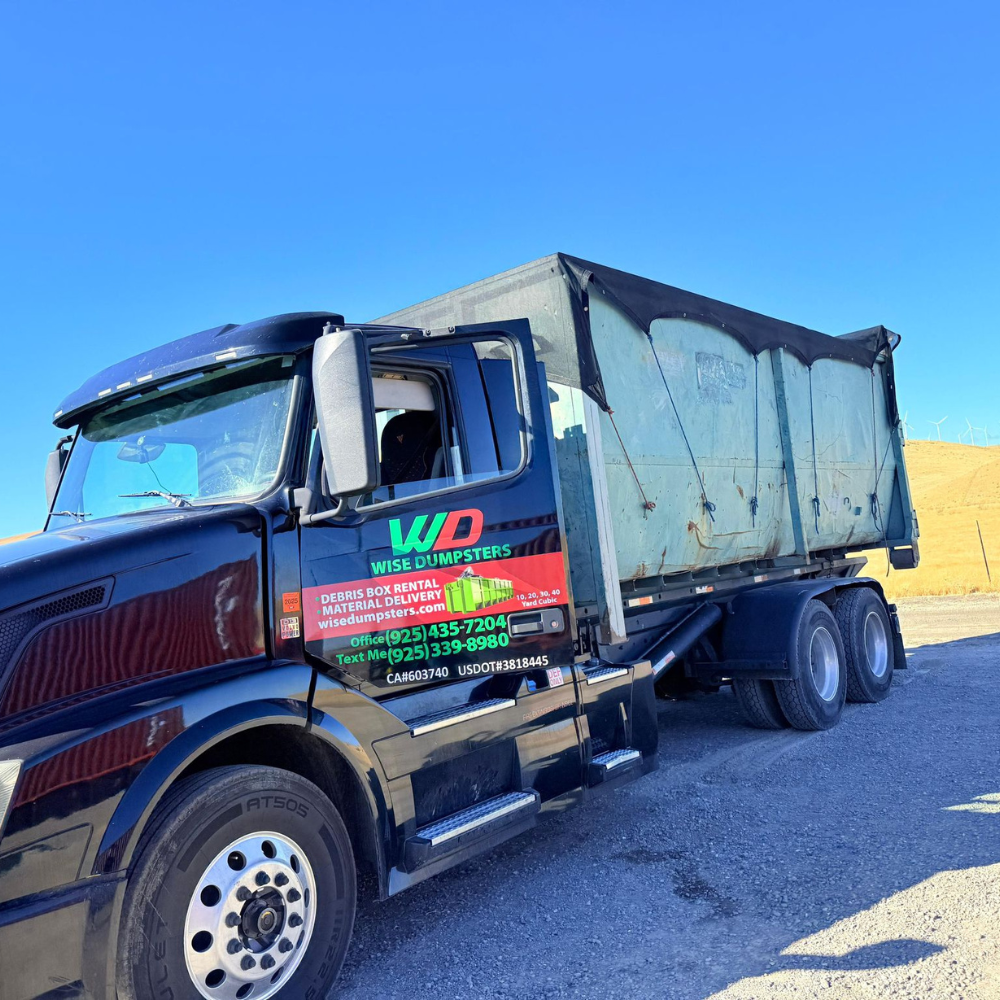 Wise Dumpsters branded truck parked with a loaded roll-off
