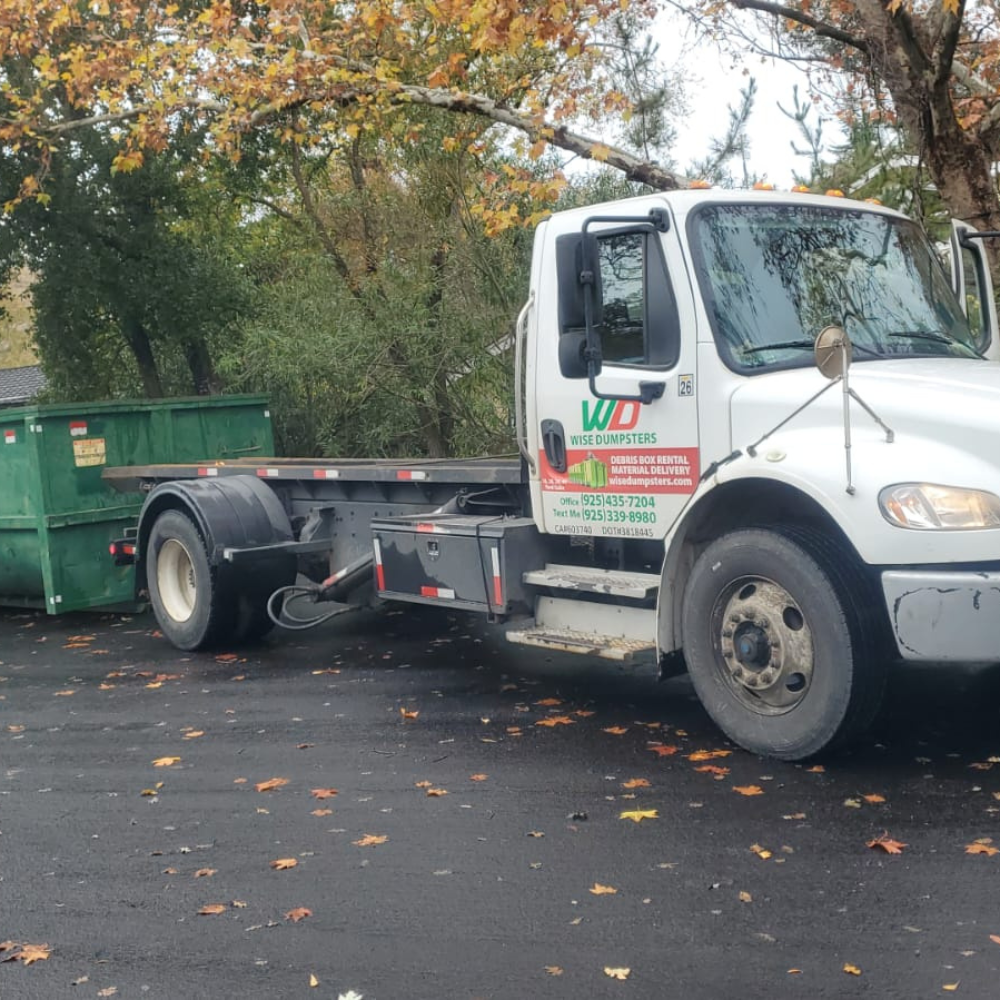 Truck and green roll-off in a tree-lined Bay Area street